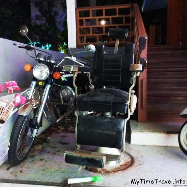 Старое парикмахерское кресло и мотоцикл
